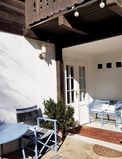 Eingangsbereich vom Bed & Breakfast mit Eingangstür, kleiner blauer Sitzbank und einem roten Teppich